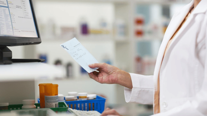 pharmacienne tenant une ordonnance dans sa main